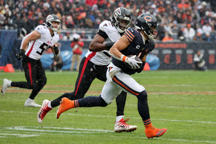 Dec 31, 2023; Chicago, Illinois, USA; Chicago Bears quarterback Justin Fields (1) rushes the ball past Atlanta Falcons defensive end Zach Harrison (96) during the first half at Soldier Field.